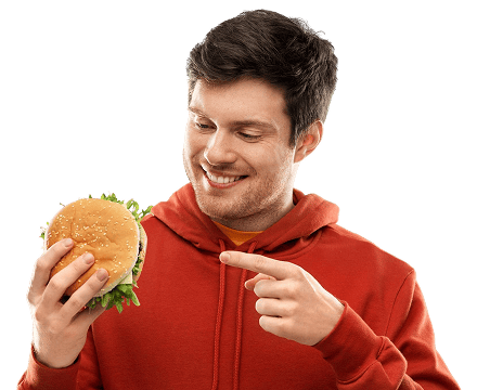 İşıq fonunda tənha, əlində burger tutub ona işarə edən gülümsəyən kişi.